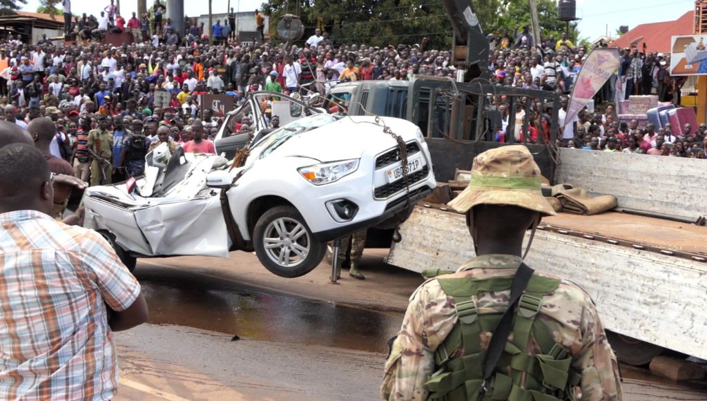 Security operatives tow away the wreckage of a Mitsubishi vehicle (RVR UBQ 371P), which was crushed by the cement mixer truck (UAN 836D) whose driver lost control at the traffic lights near Nkumba University along Kampala-Entebbe expressway on April 17, 2024